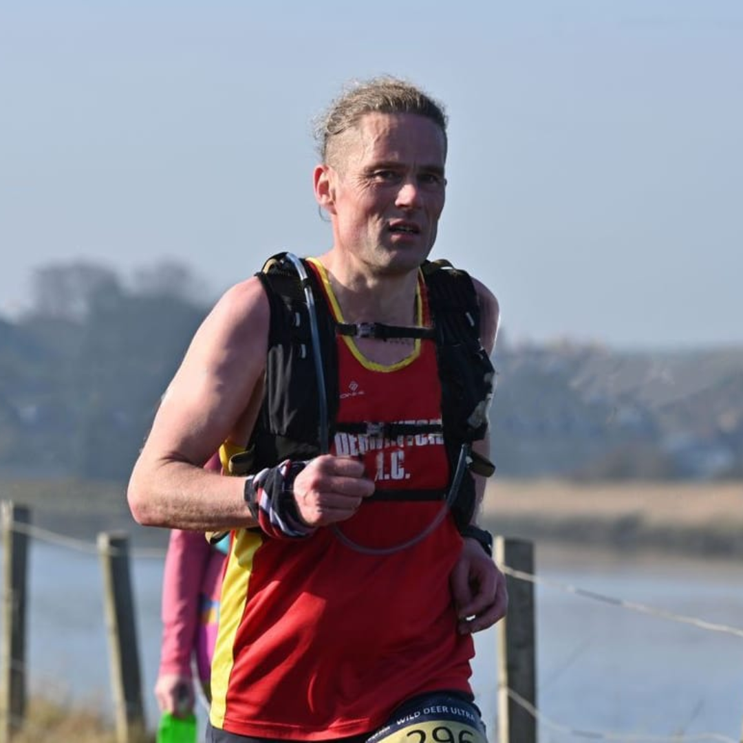 Graham Marshall taking part in a race. He is wearing his DAC vest and has a race pack on. 